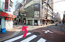 Pass the Family Mart and turn left at the next corner. The street should have a school on the right-hand side and a yakiniku restaurant and tobacco shop on the left.